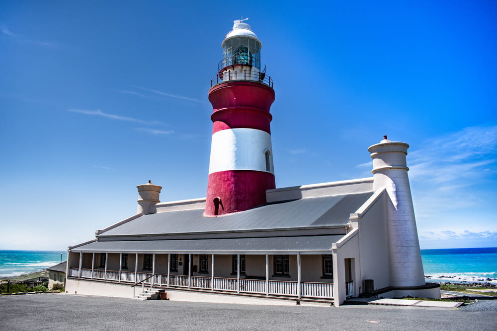 red and white concrete lighthouse under blue sky during daytime