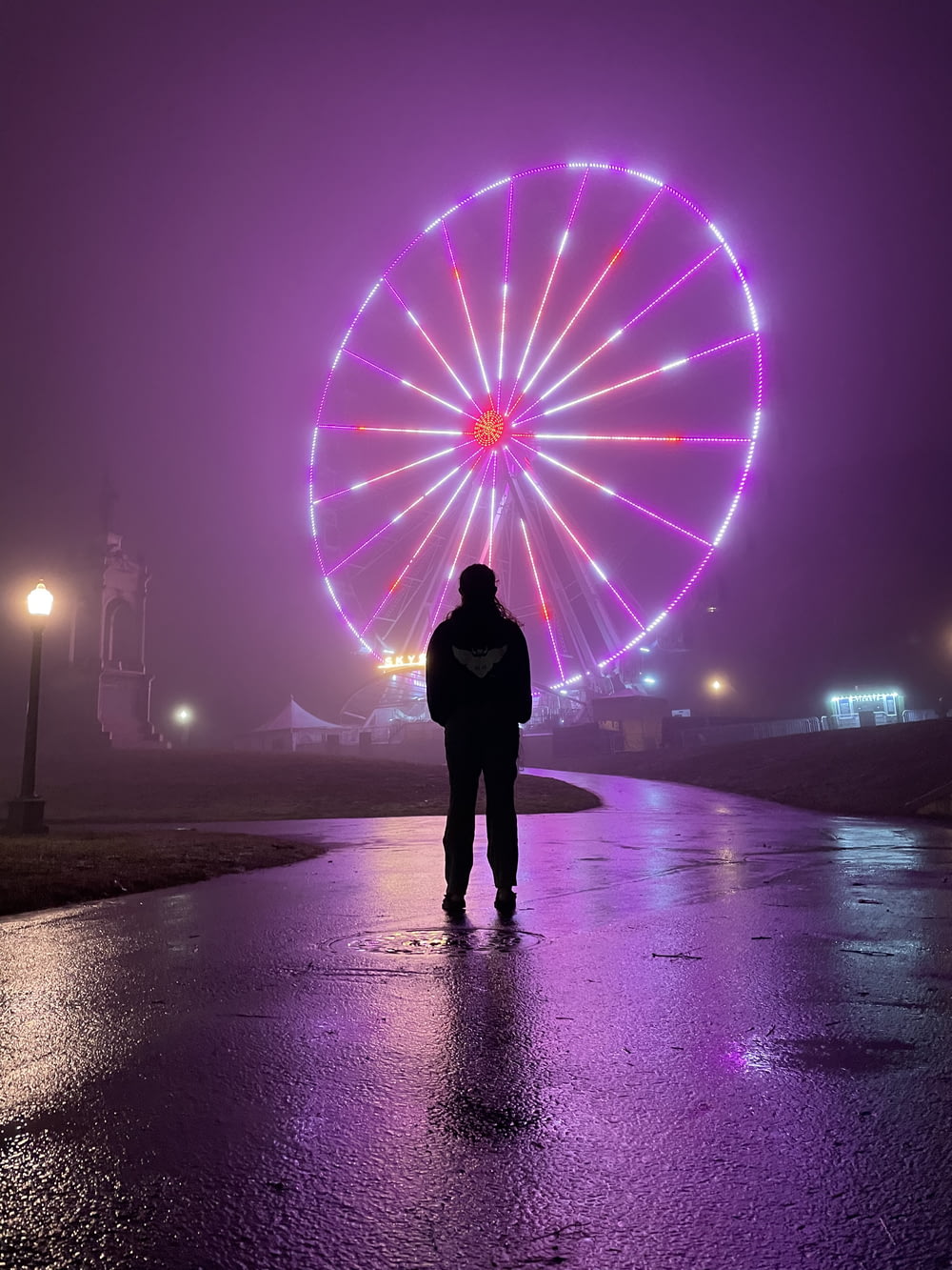 person standing on beach with purple lights