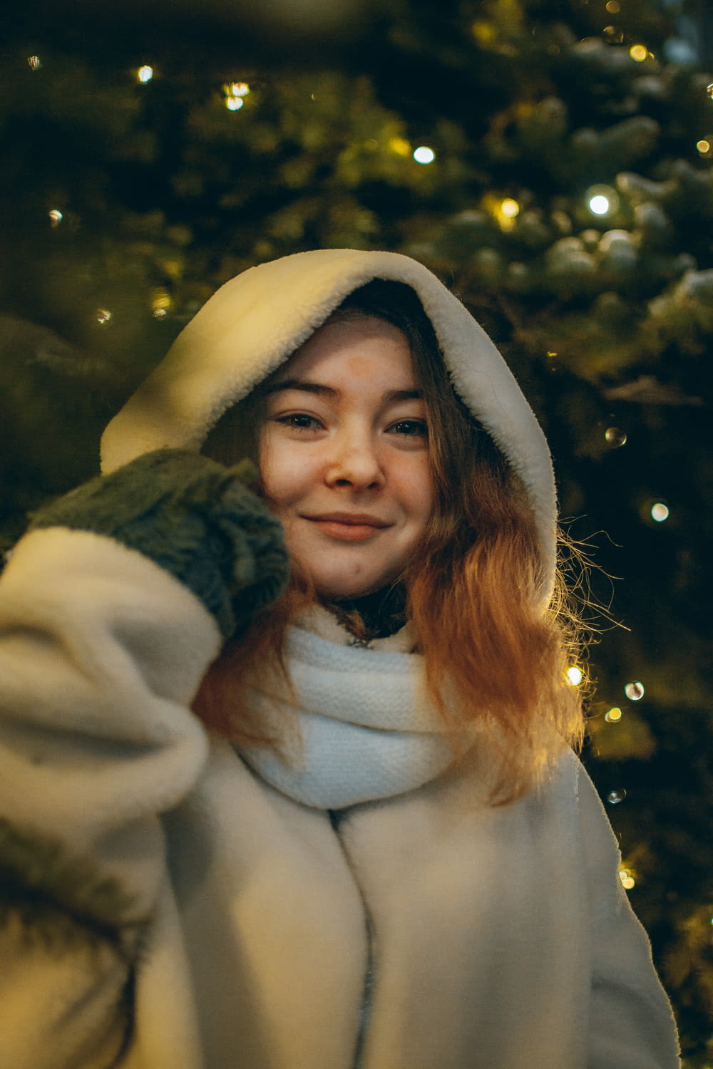 woman in white and green coat smiling