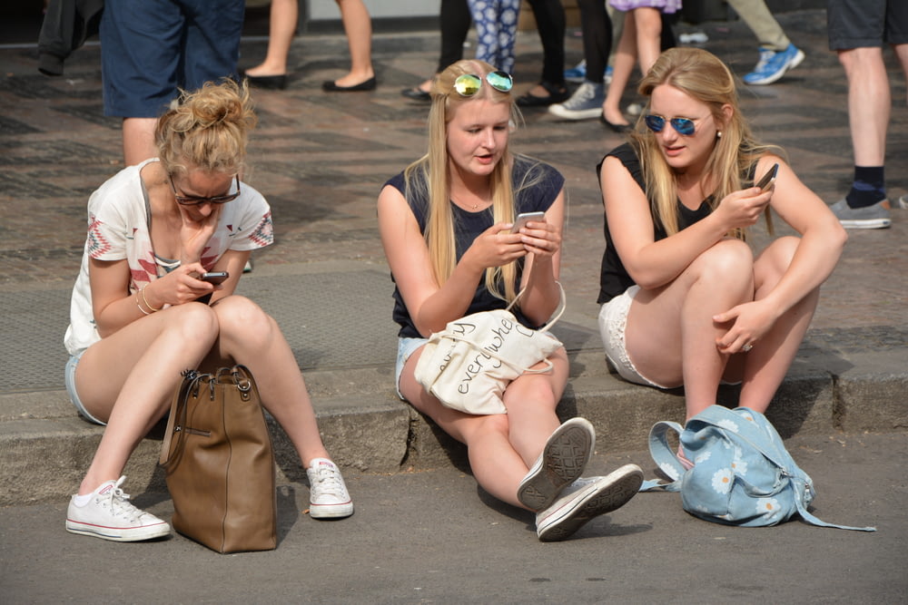 3 mujeres sentadas en el suelo de hormigón gris durante el día