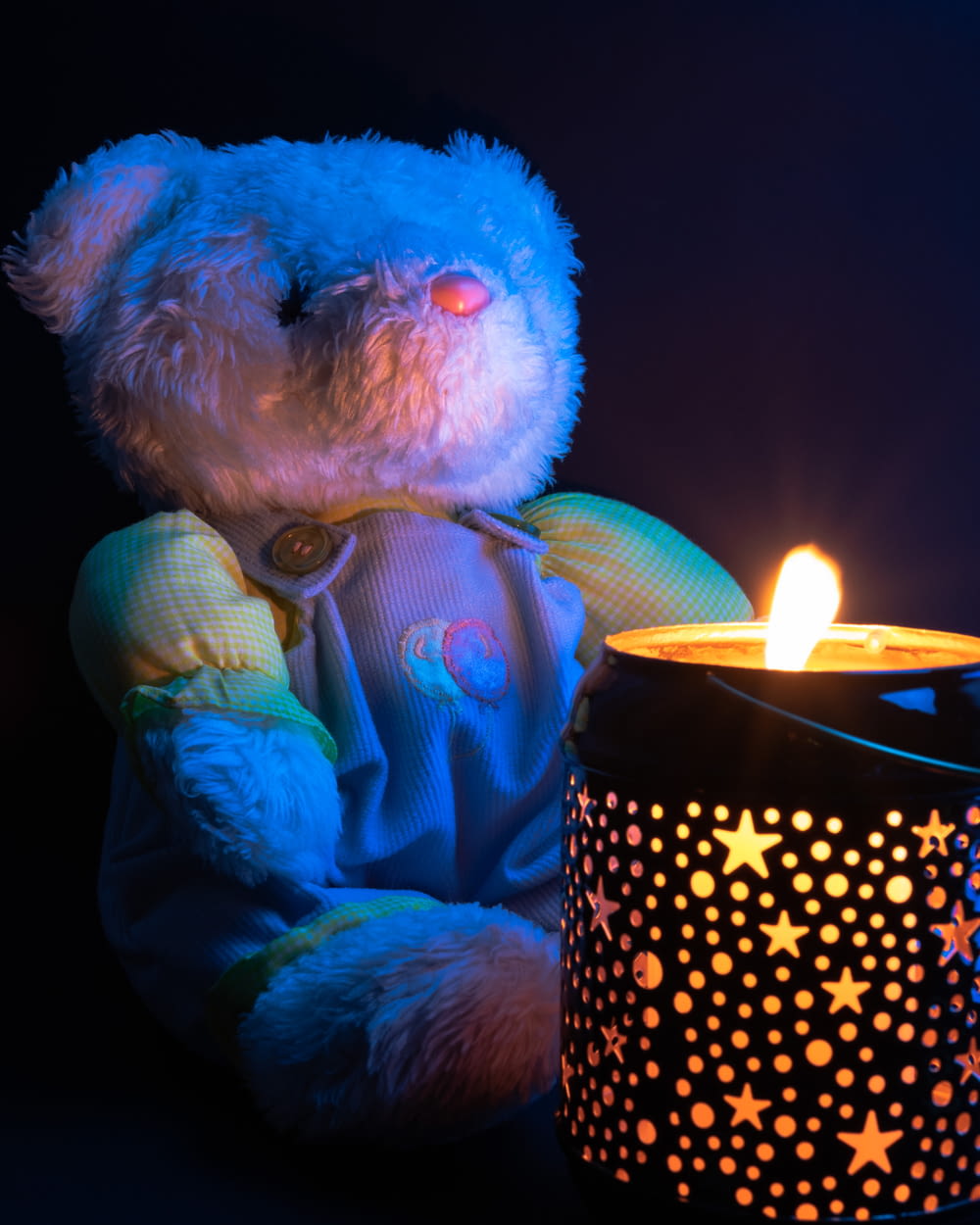 white bear plush toy holding lighted candle
