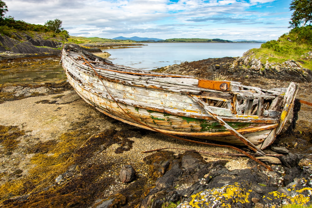 brown wooden boat on shore during daytime