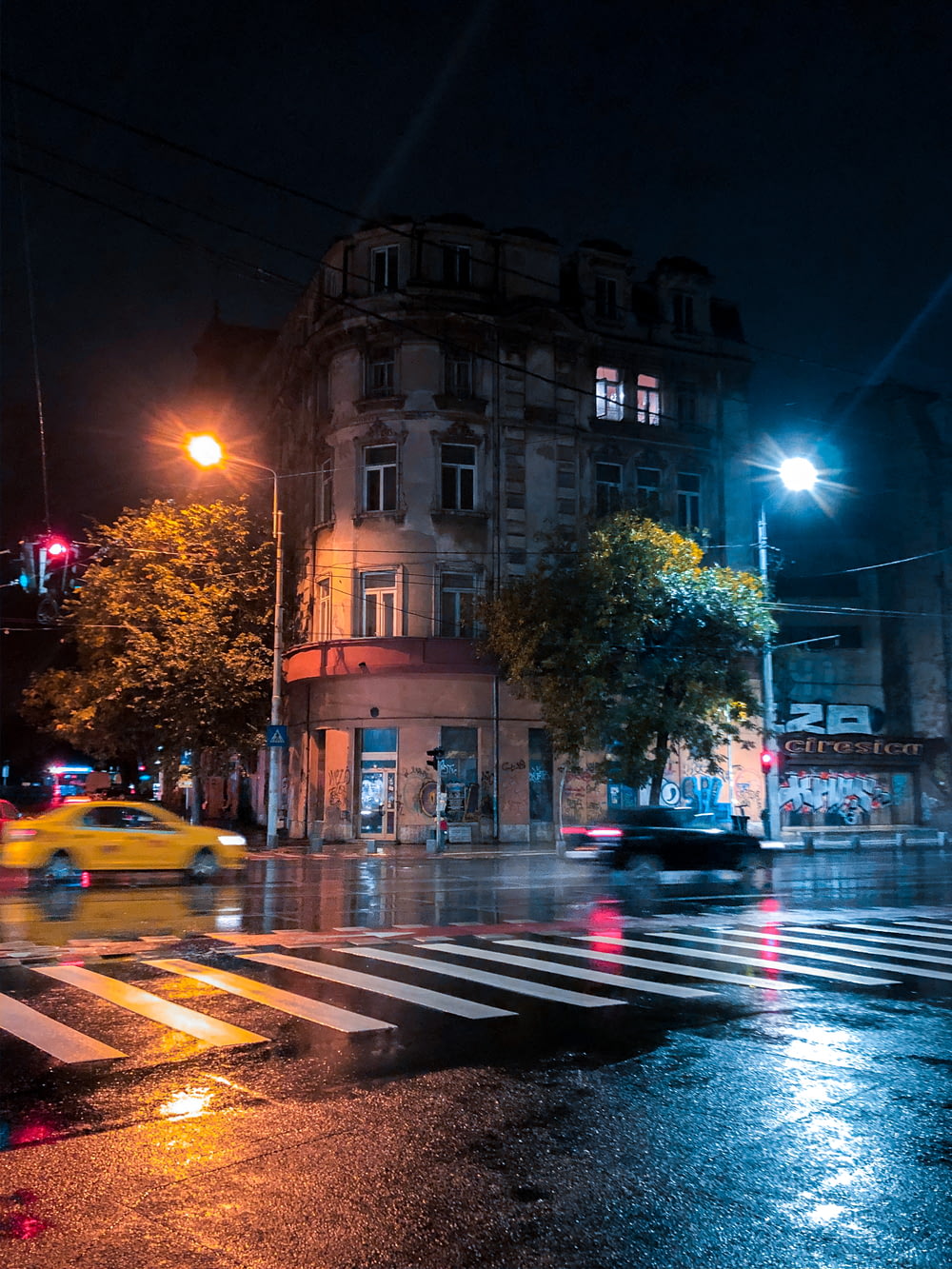야간에 갈색 콘크리트 건물 근처 도로에 있는 자동차