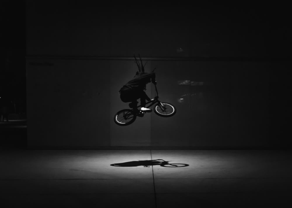 Graustufenfoto von Mann beim Fahrradfahren