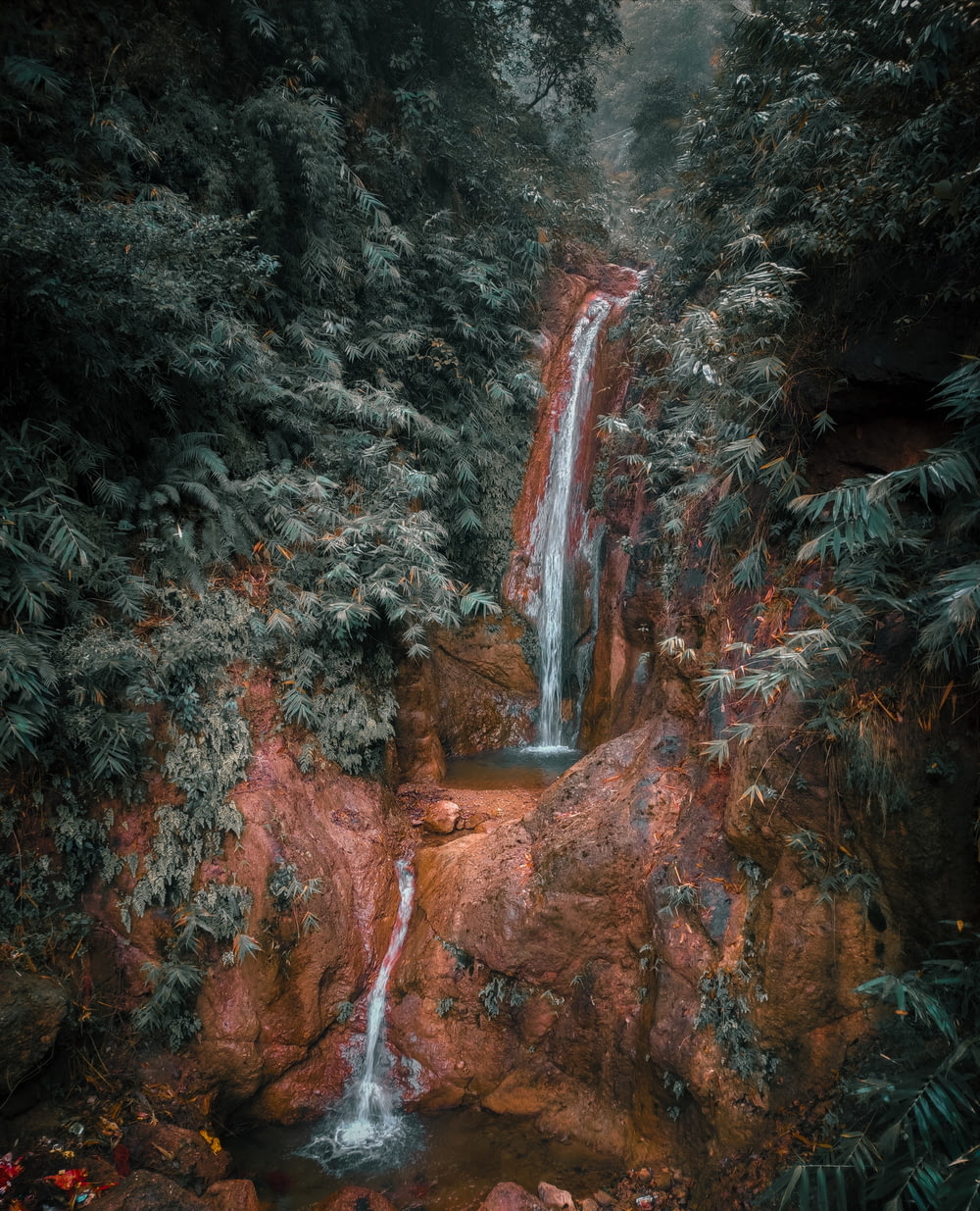 waterfalls in the middle of forest during daytime
