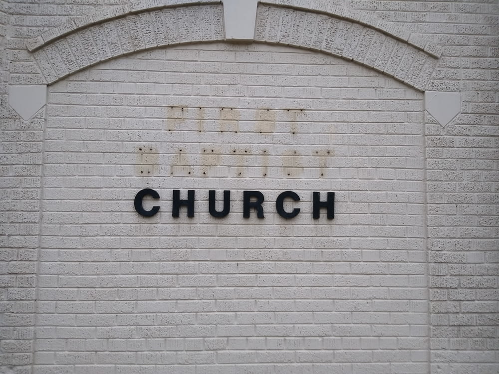 Un muro di mattoni con un cartello che dice, la chiesa