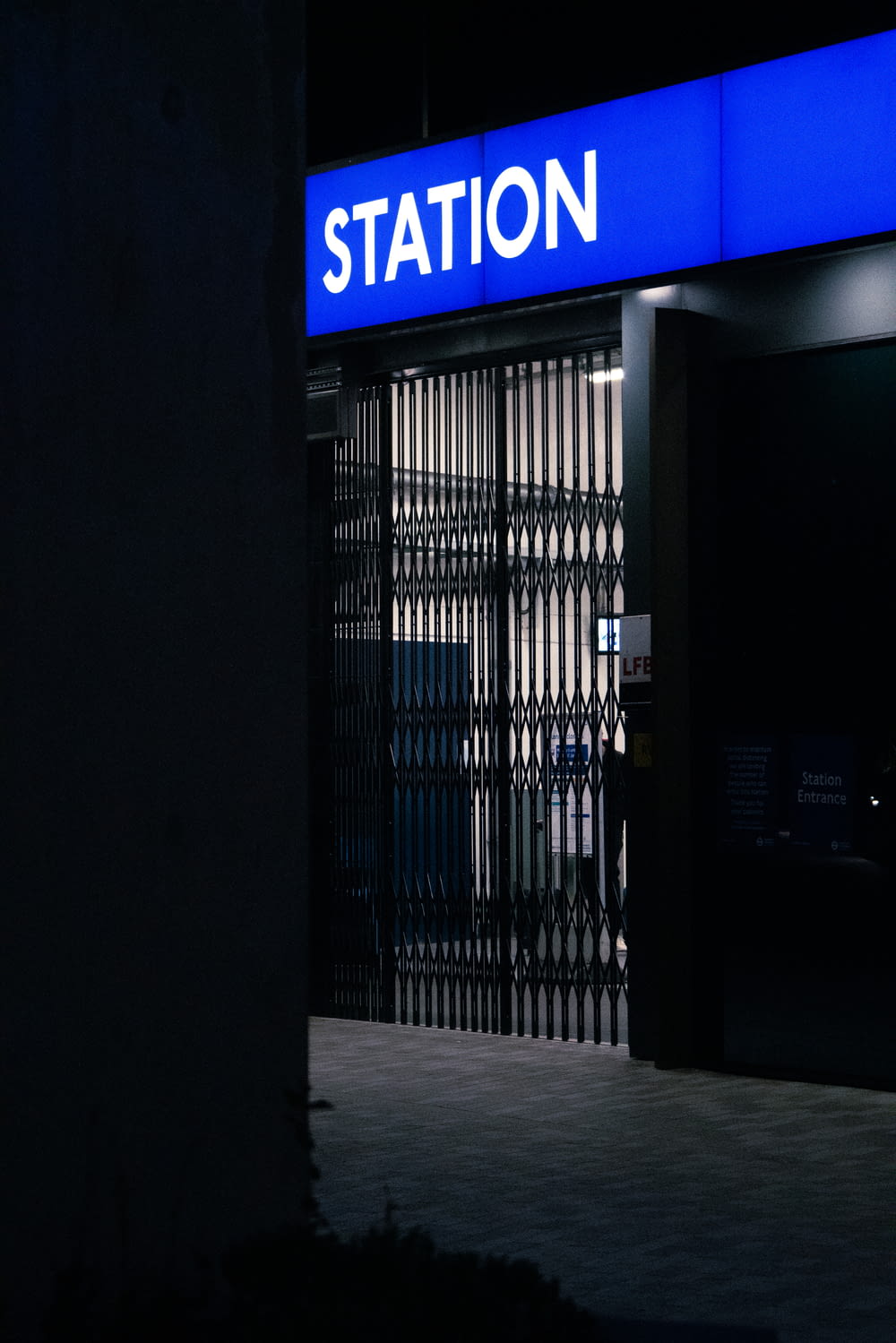 black metal gate near blue and white signage