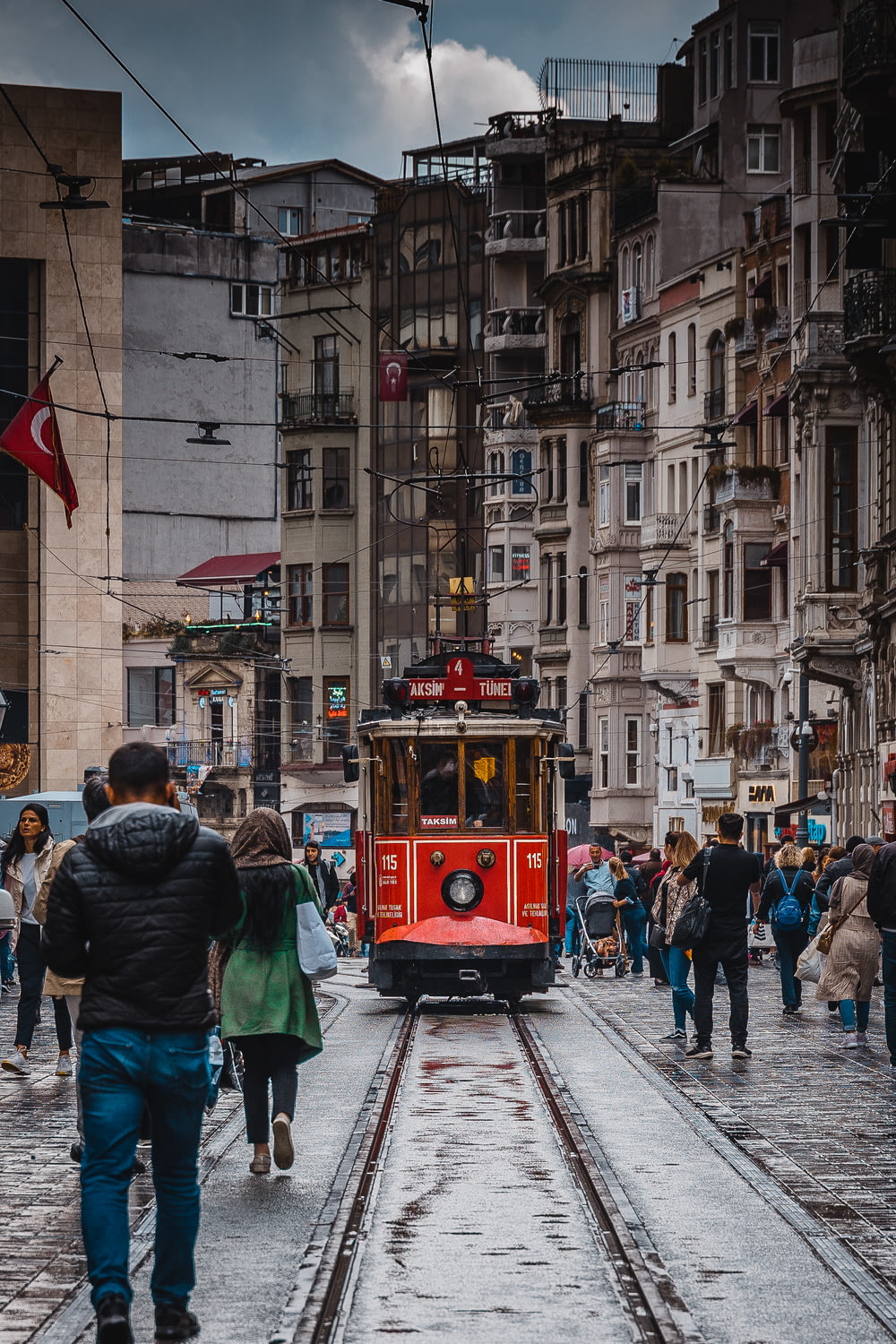 people walking on street near red tram during daytime