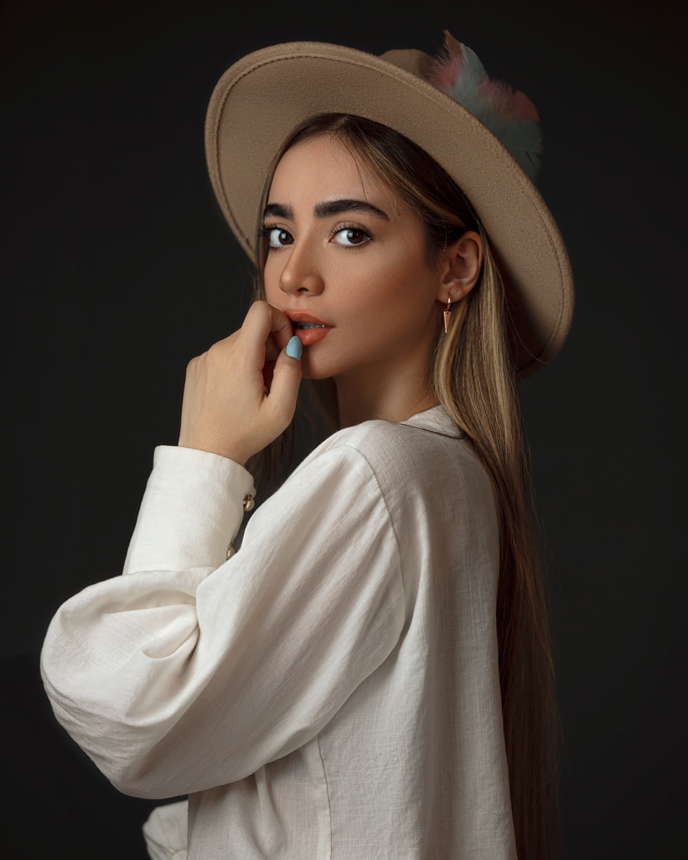 Frau im weißen Langarmhemd mit braunem Hut