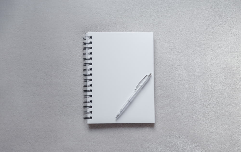 Cuaderno blanco con bolígrafo en la parte superior