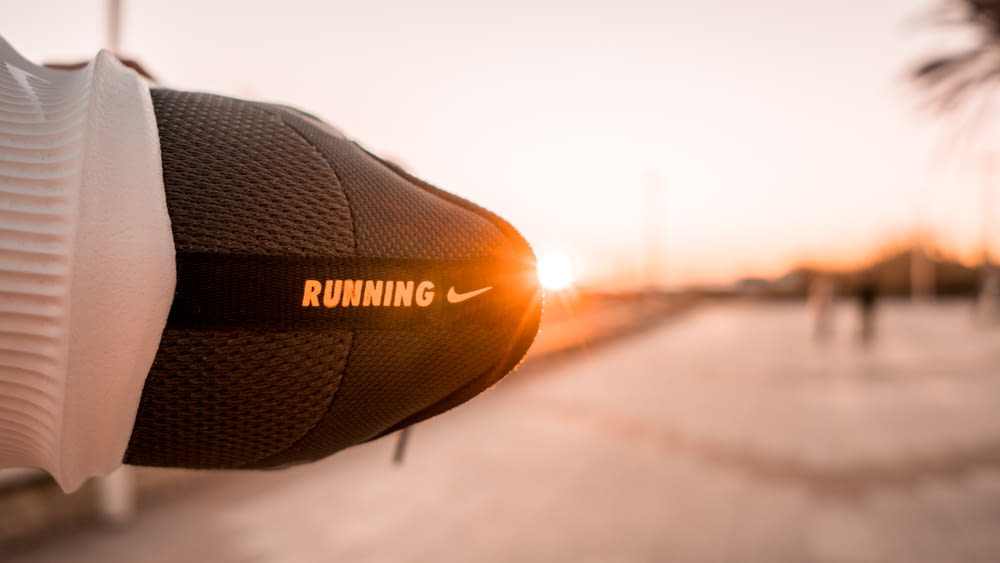 a pair of running shoes with the sun setting in the background