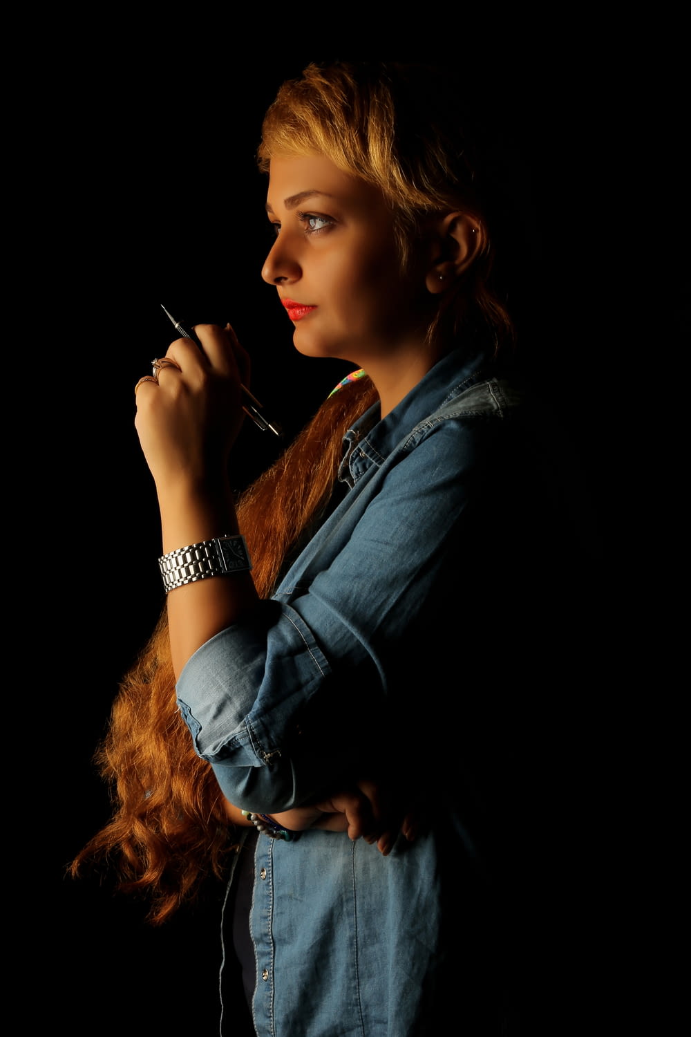 Frau in schwarzem Langarmhemd raucht Zigarette