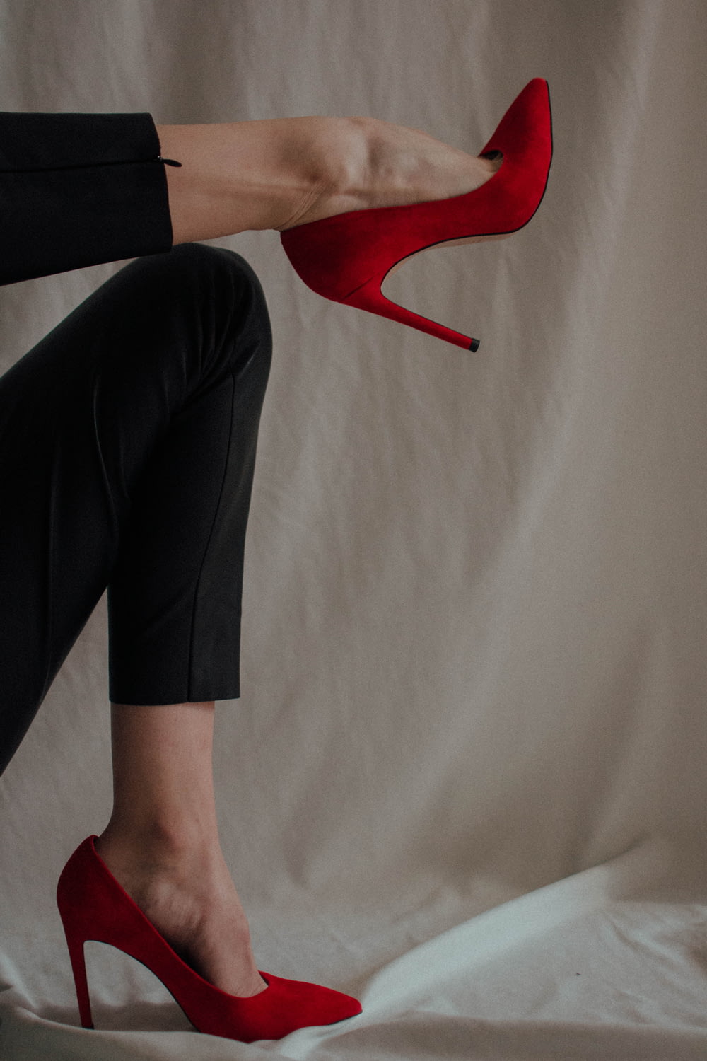 Person in schwarzen Hosen und roten Schuhen