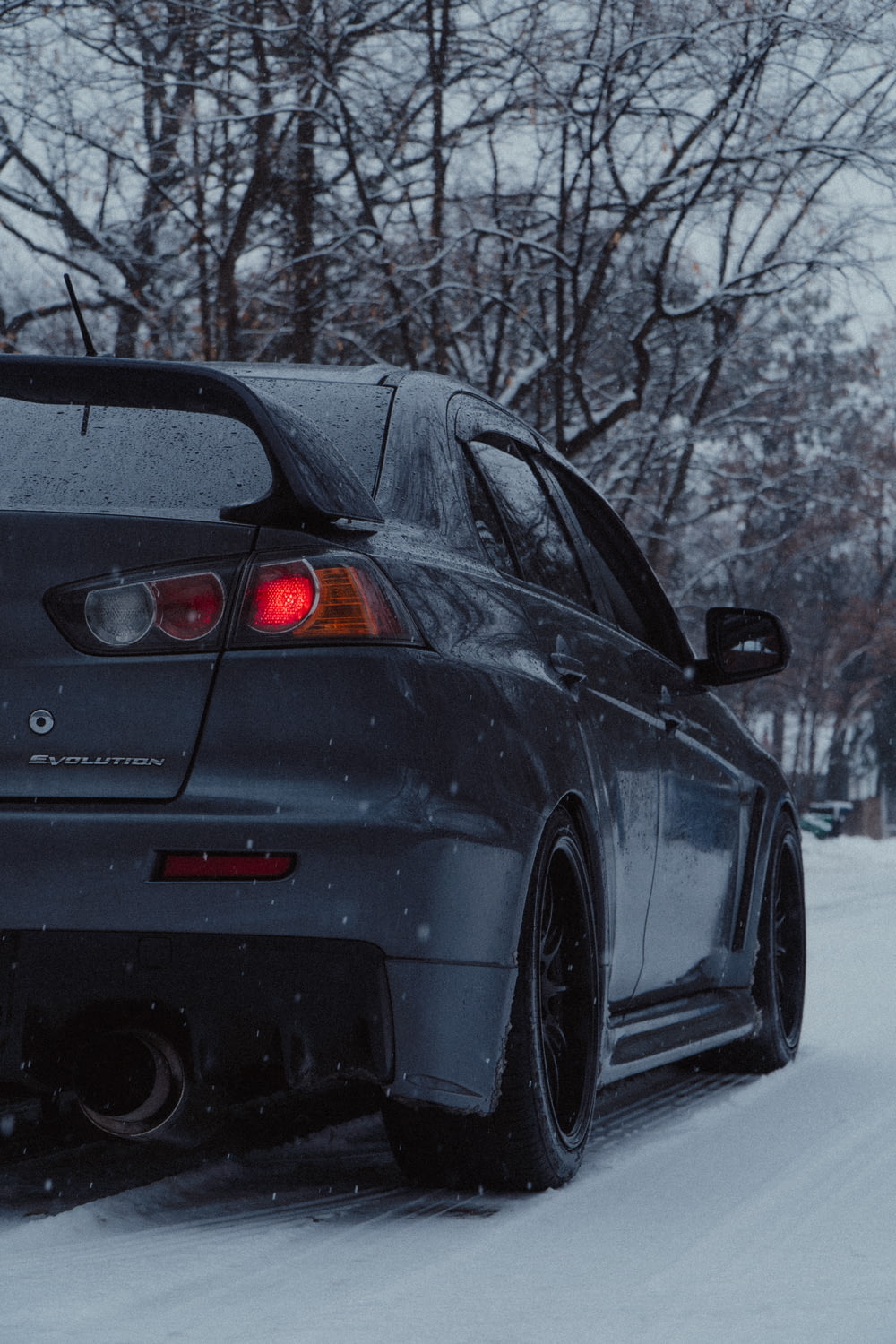 black bmw car on snow covered road during daytime