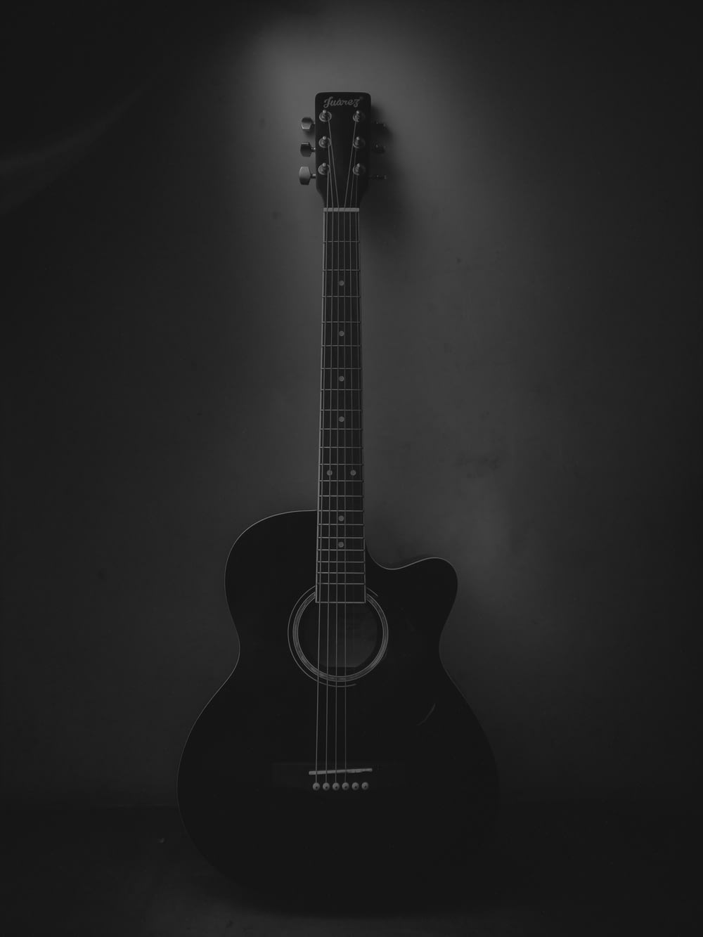 black acoustic guitar on black background