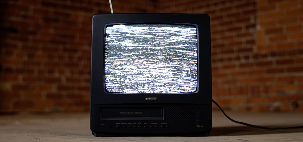 TV CRT nera su tavolo di legno marrone