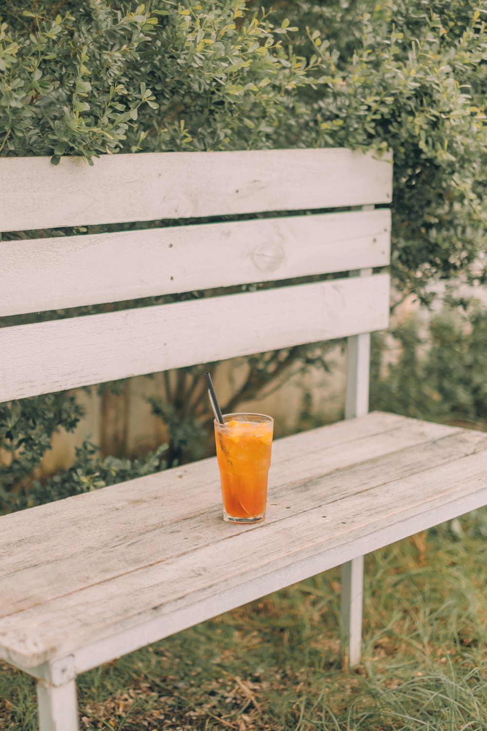 clear drinking glass with orange juice on brown wooden table