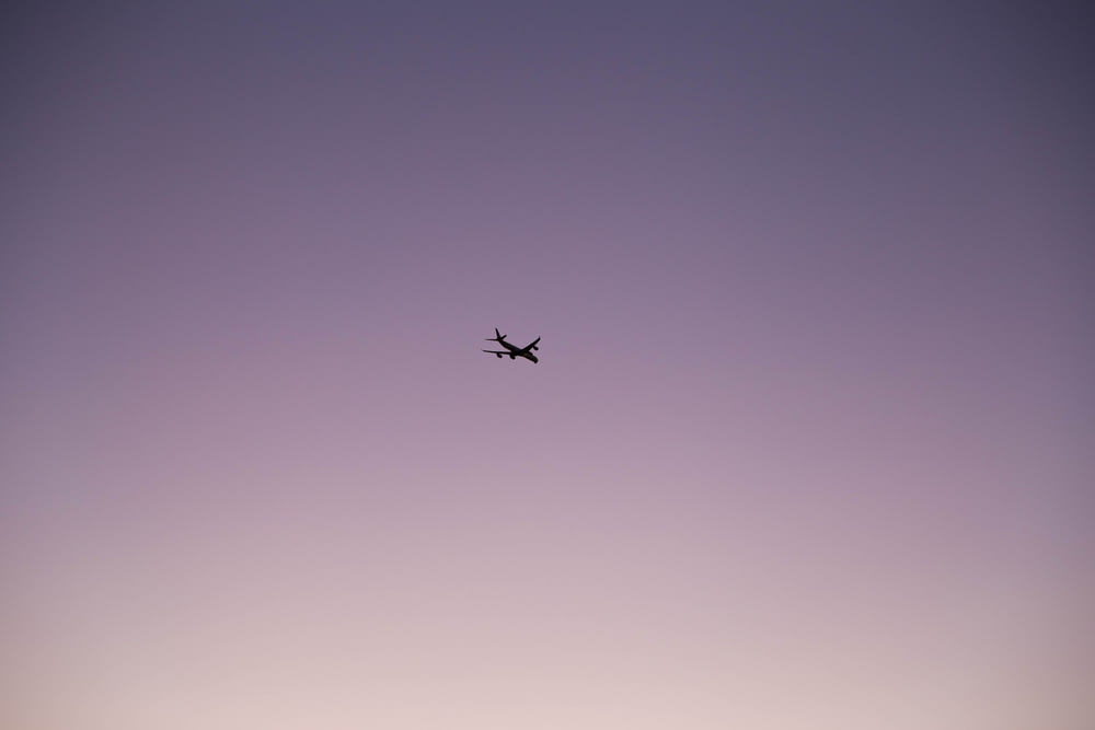 an airplane flying in the sky at dusk
