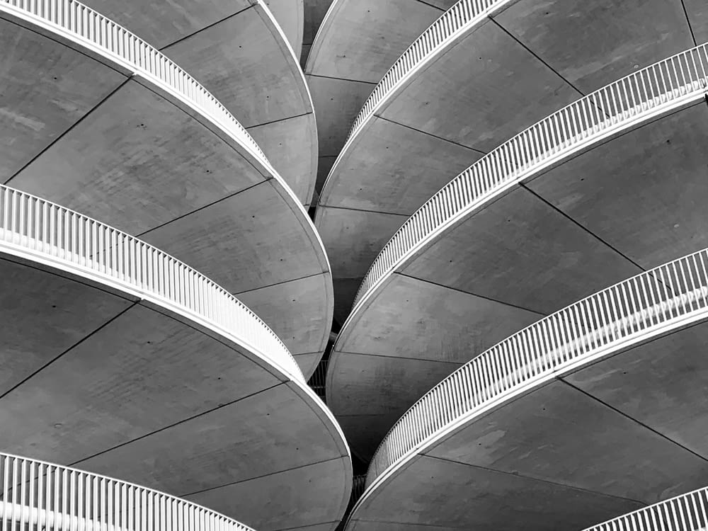 gray concrete spiral stairs in grayscale photography