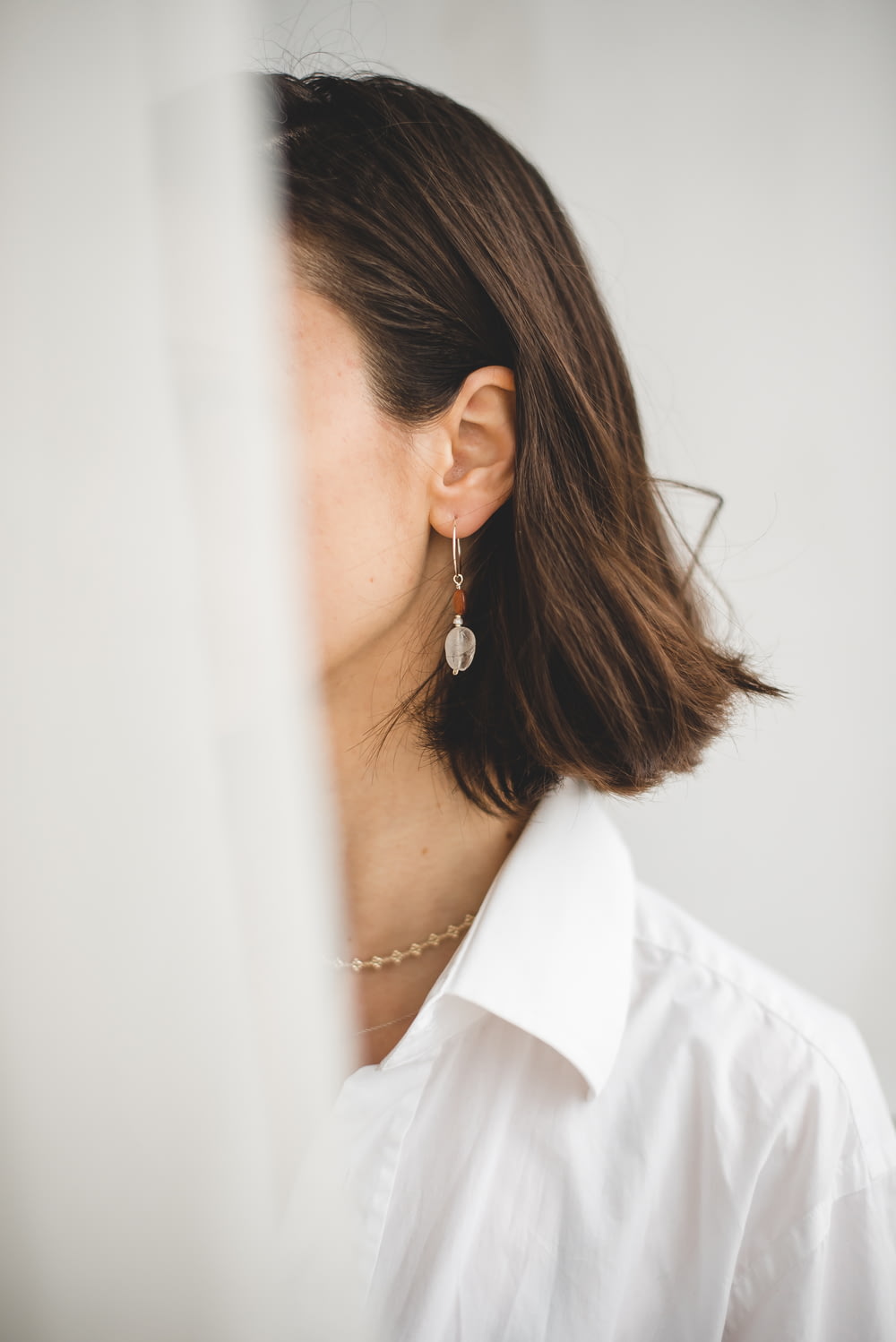 Femme en chemise blanche portant des boucles d’oreilles en argent