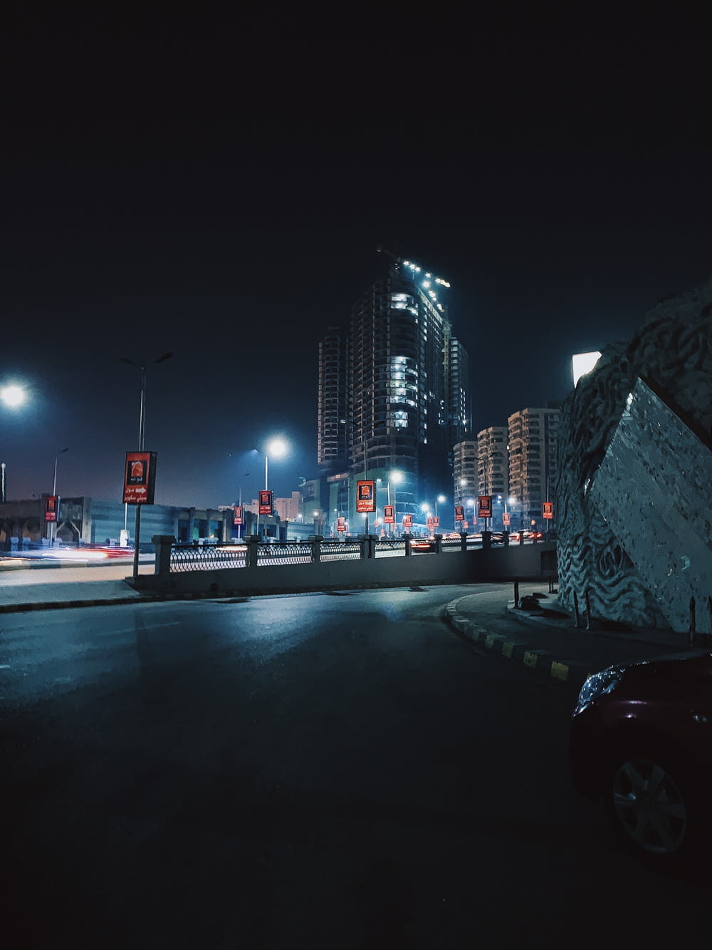 夜間に市の建物の近くの道路を走る車