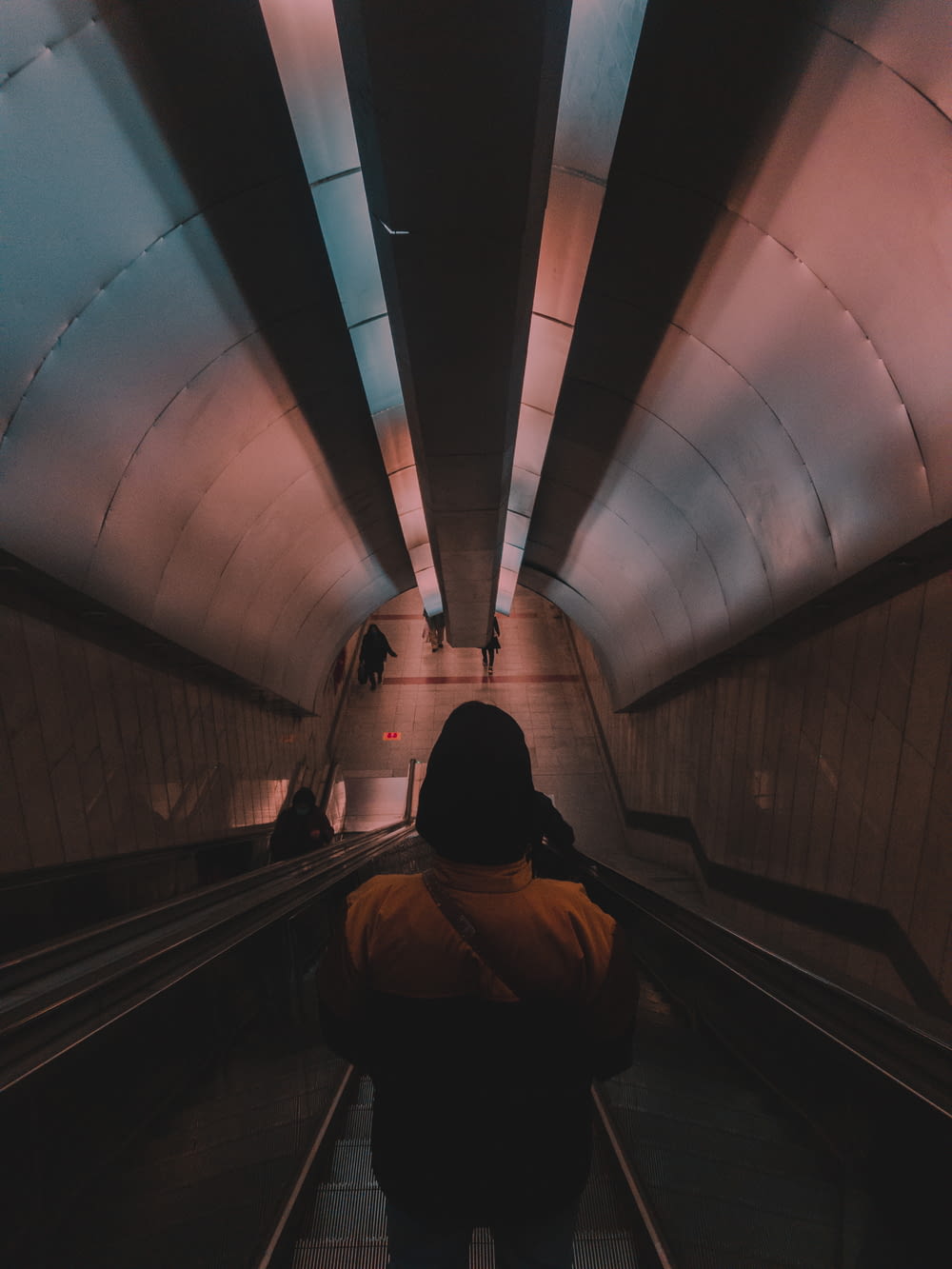 man in black jacket walking on tunnel