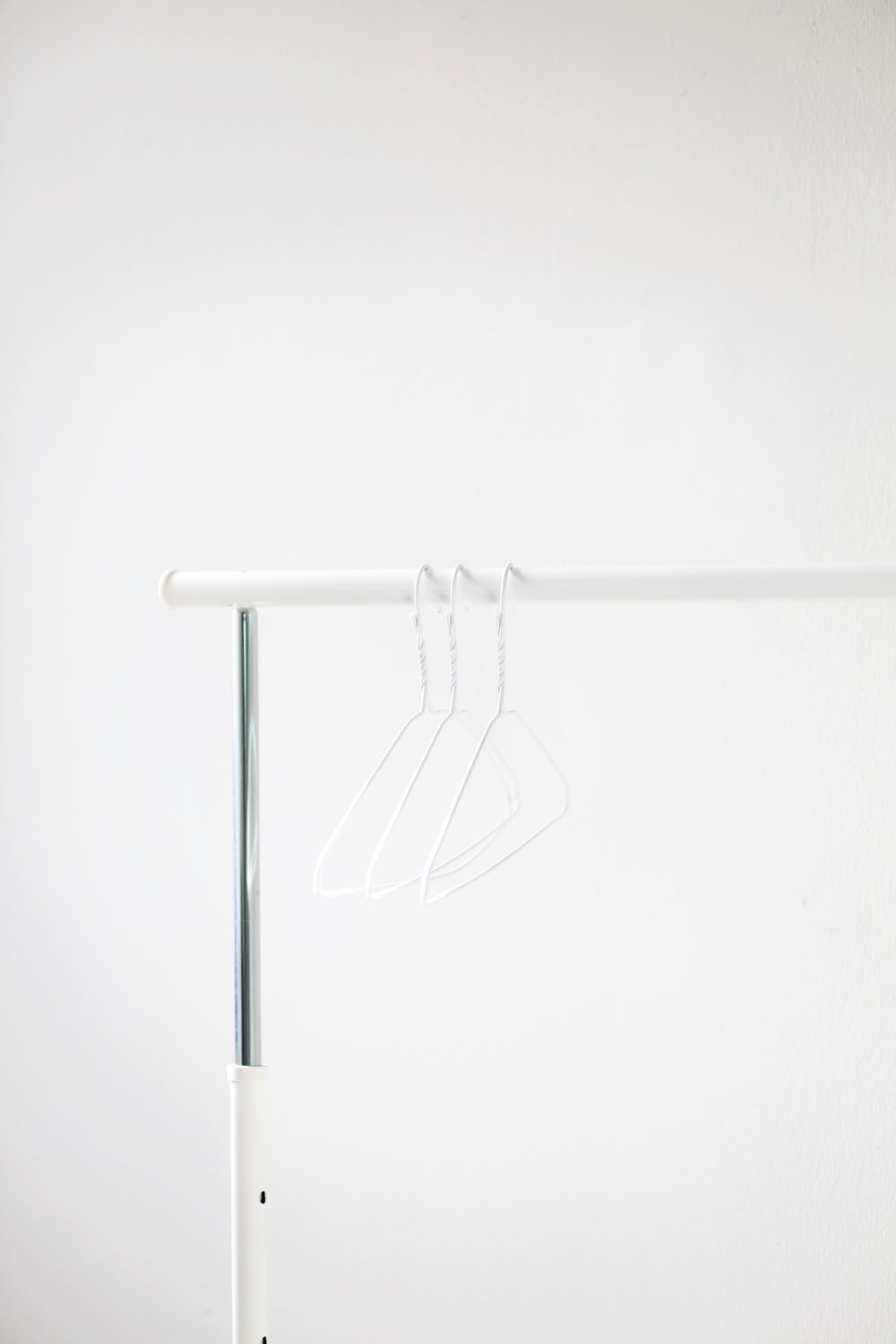 white clothes hanger on white metal bar