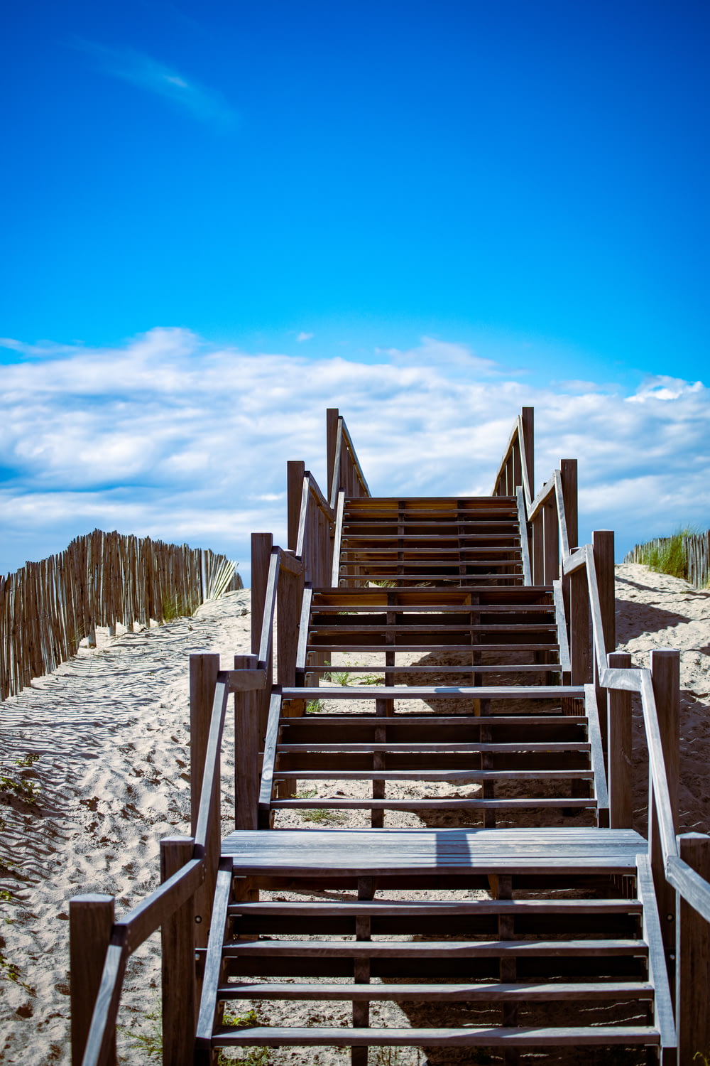 Escaleras de madera marrón sobre arena blanca durante el día