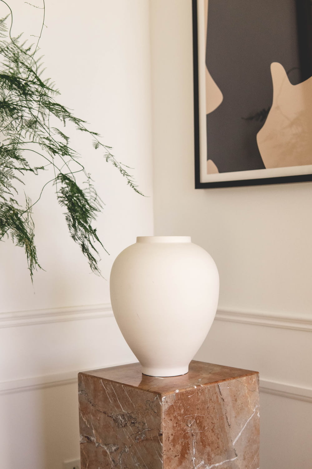 Jarrón de cerámica blanca sobre mesa de madera marrón