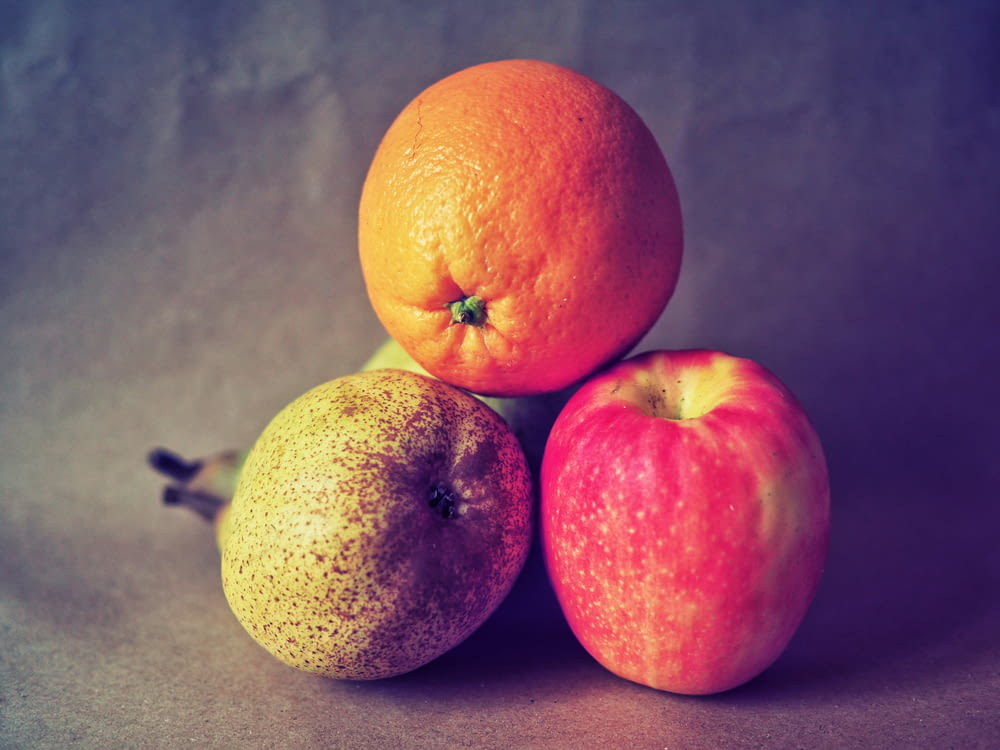 due frutti arancioni su superficie grigia