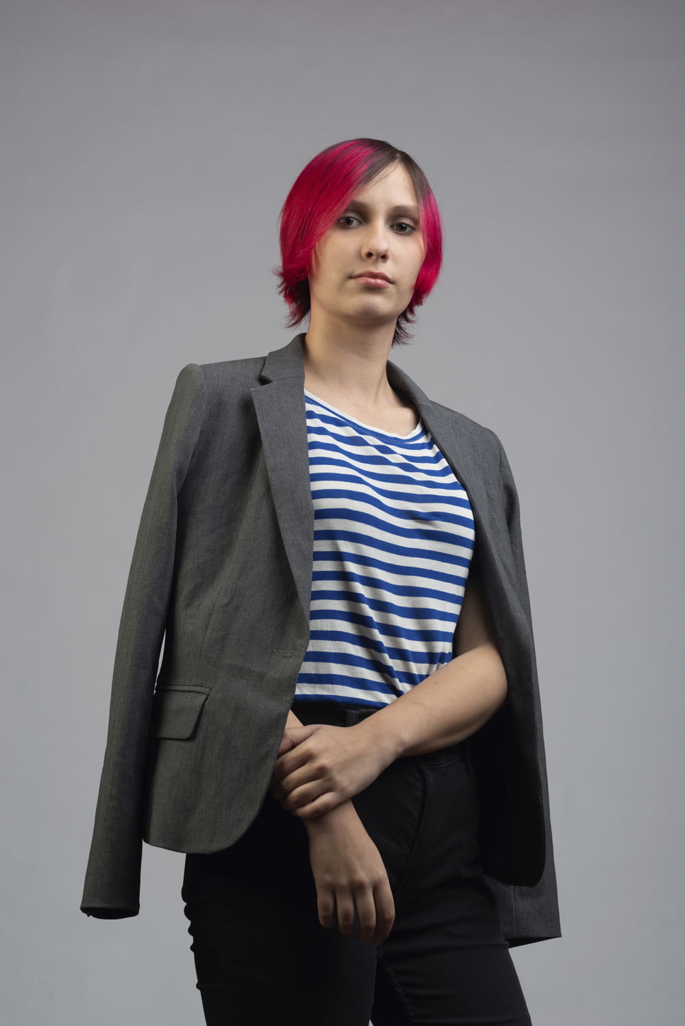 a woman with red hair wearing a gray jacket