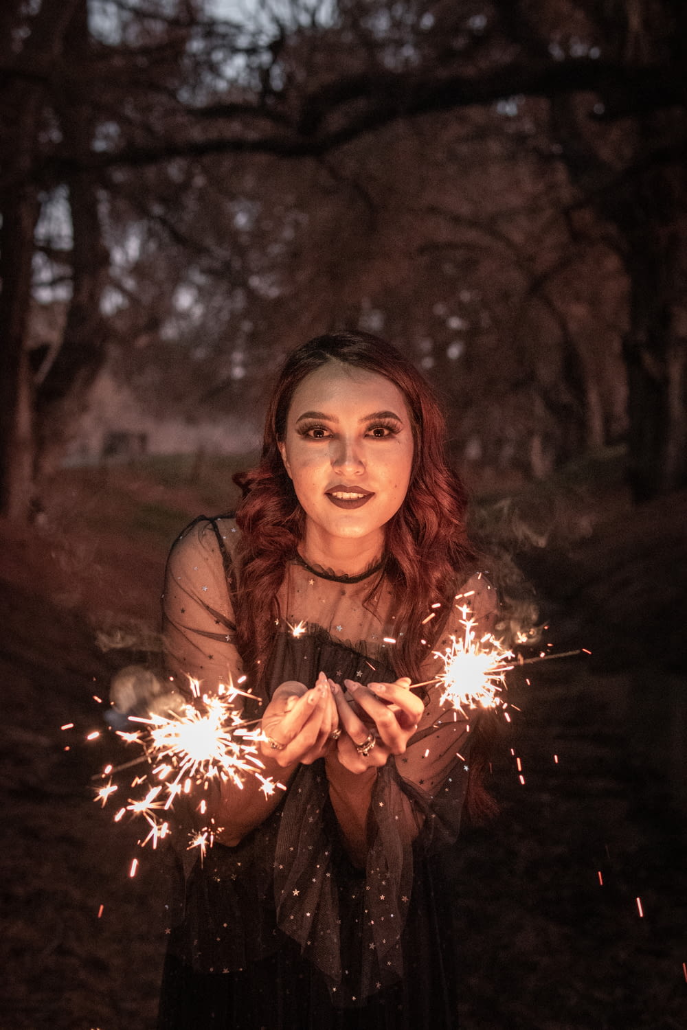 woman in brown long sleeve shirt holding sparkler