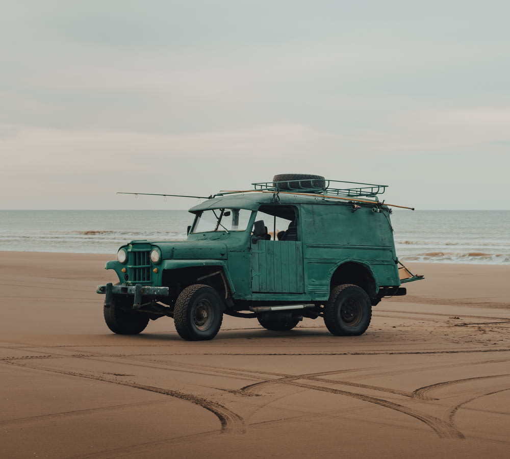 green suv on brown sand beach during daytime