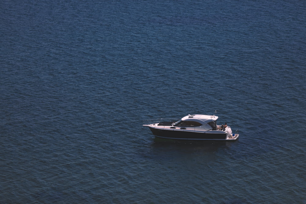 white and black motor boat on blue sea during daytime