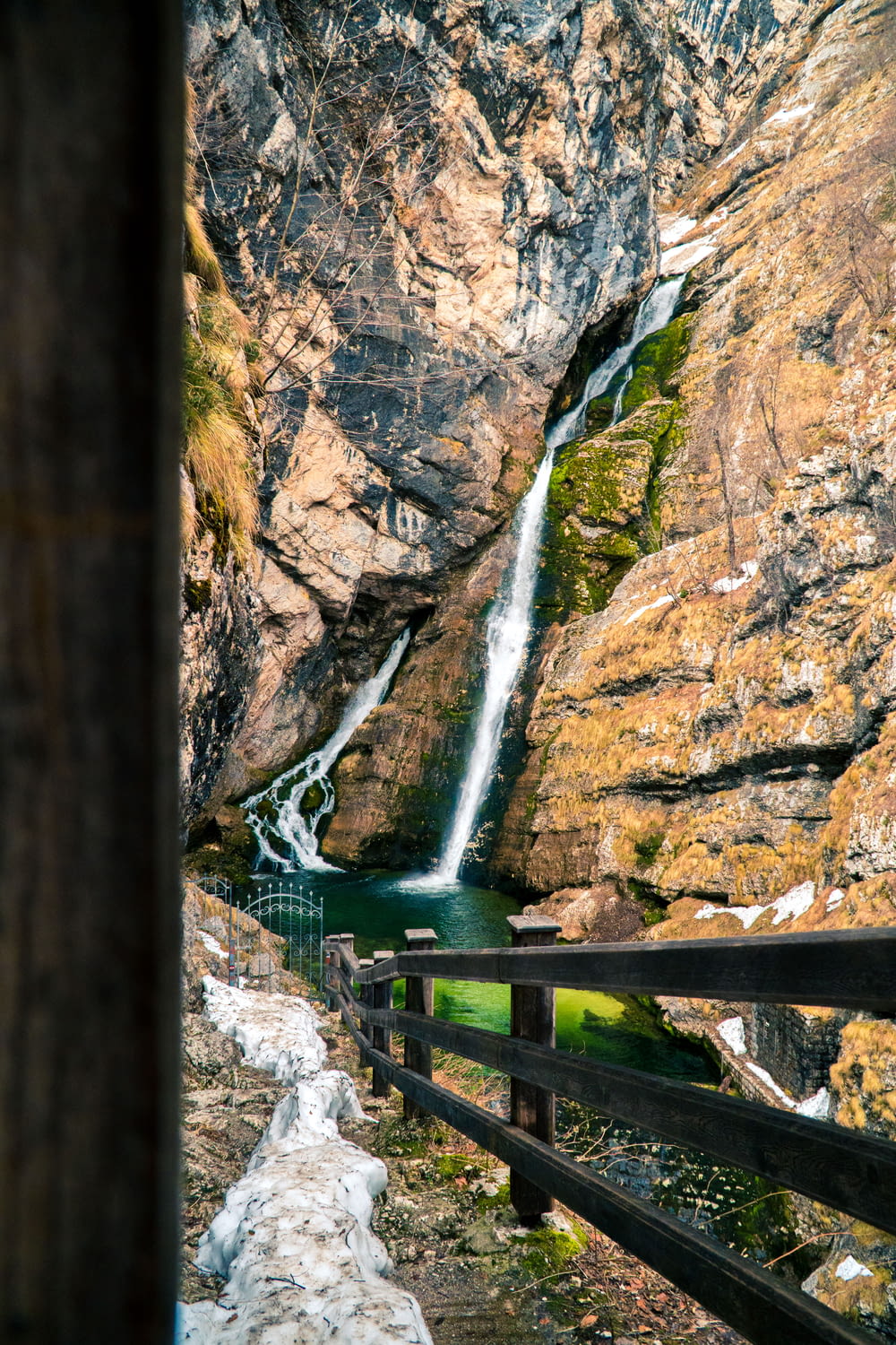 green wooden bridge over water falls