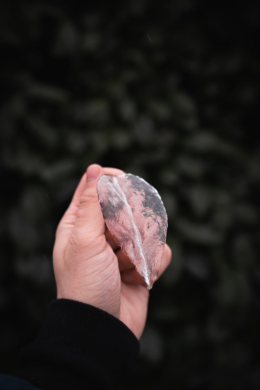 person holding pink and white stone