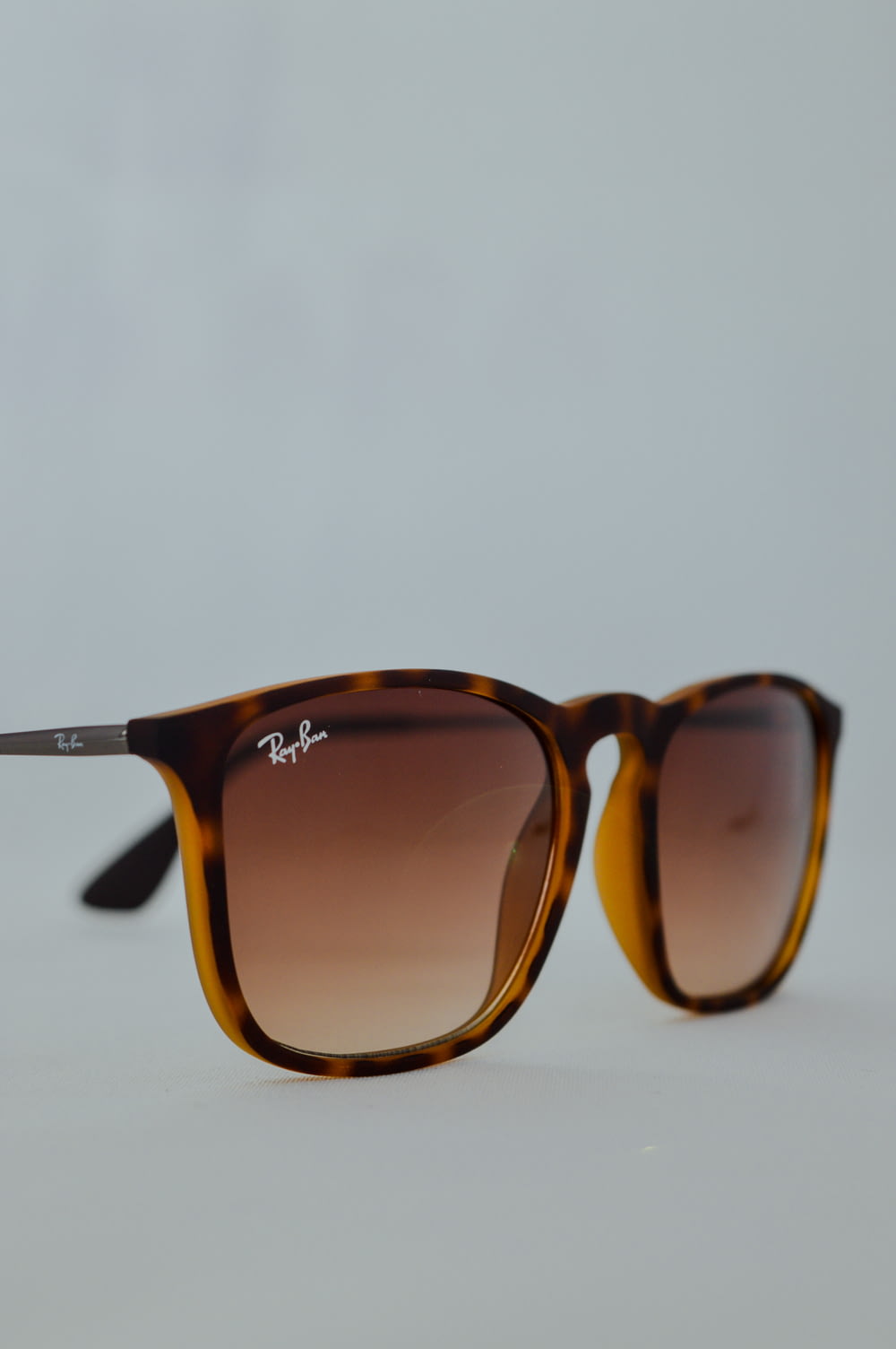 brown framed sunglasses on white surface