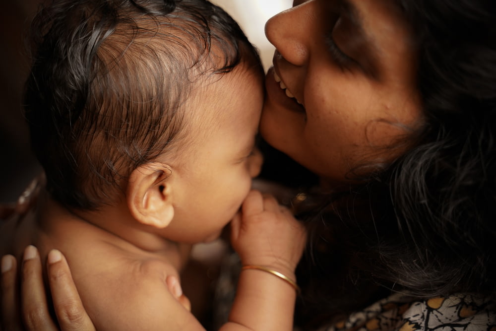 Mujer besando al bebé en la mejilla