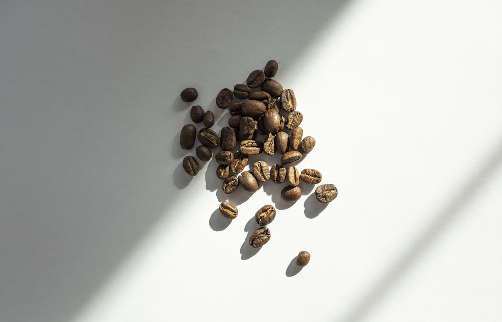 白いテーブルの上の茶色のコーヒー豆