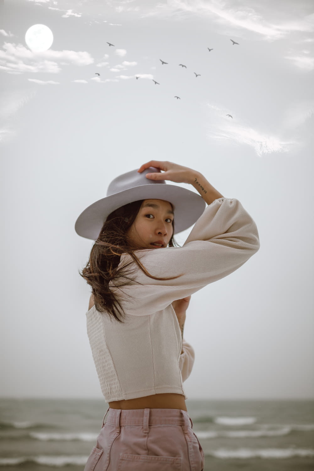 woman in white long sleeve shirt wearing white hat