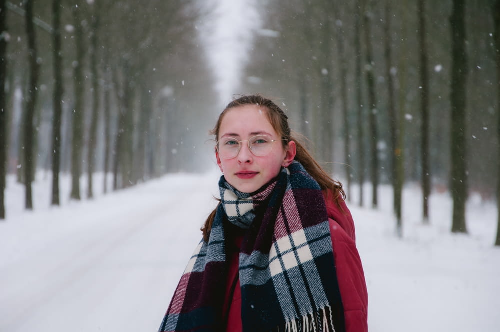 woman in red white and black scarf on snow covered ground during daytime