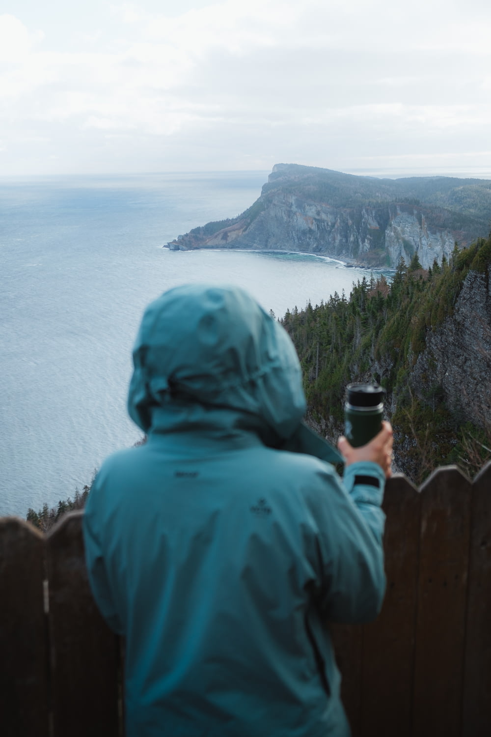 person in blue hoodie taking photo of sea during daytime