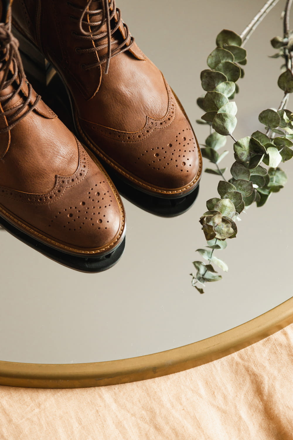 scarpe di cuoio marrone sul tavolo bianco
