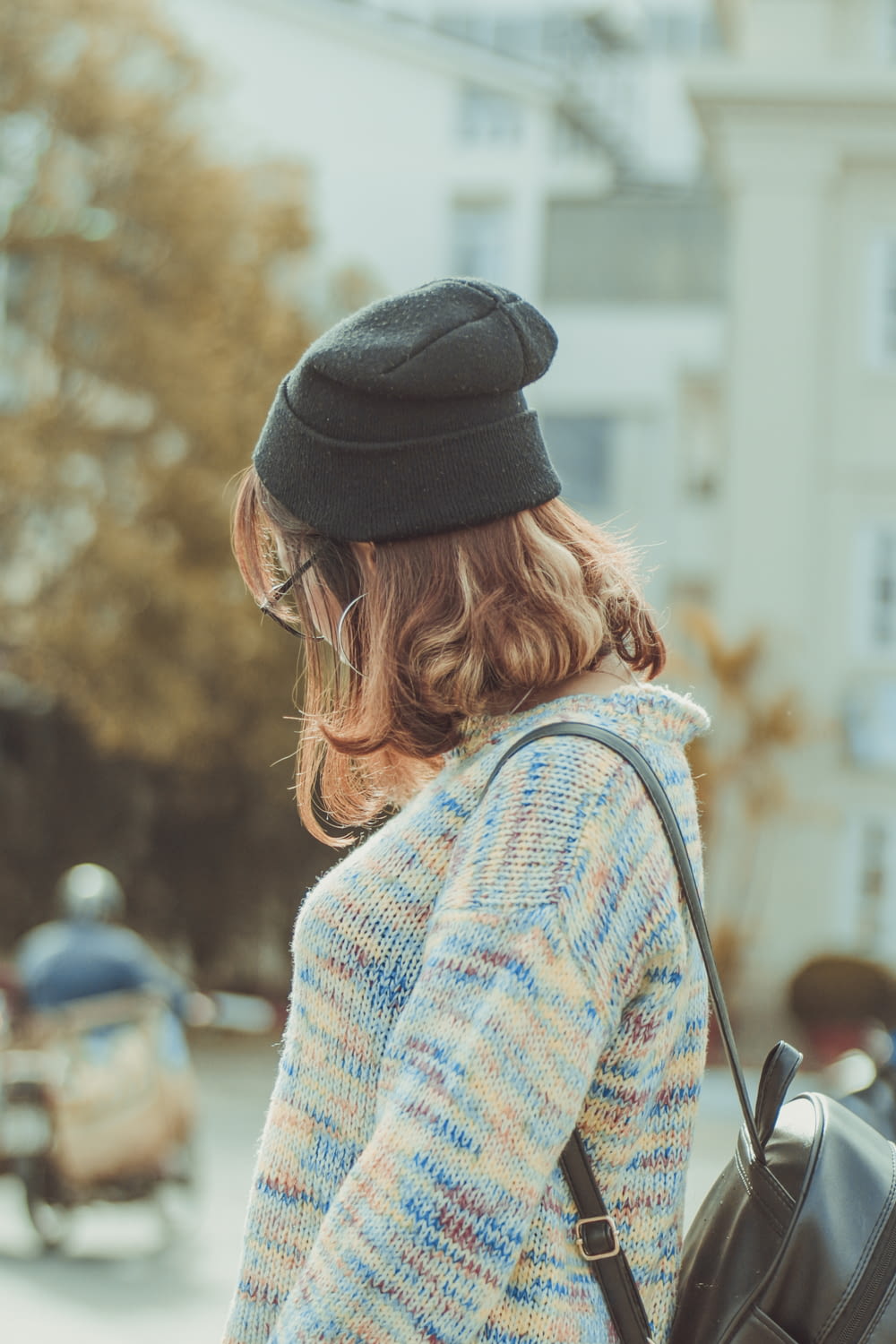 woman in white and blue knit sweater wearing black knit cap