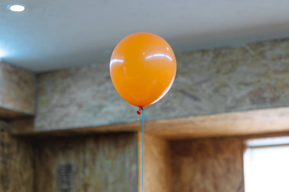 orange balloon on white wall