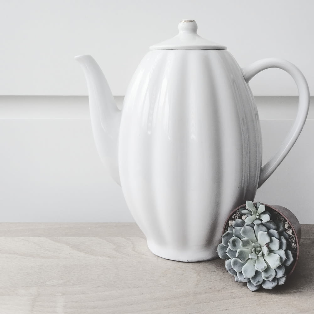 silver and black teapot on brown wooden table
