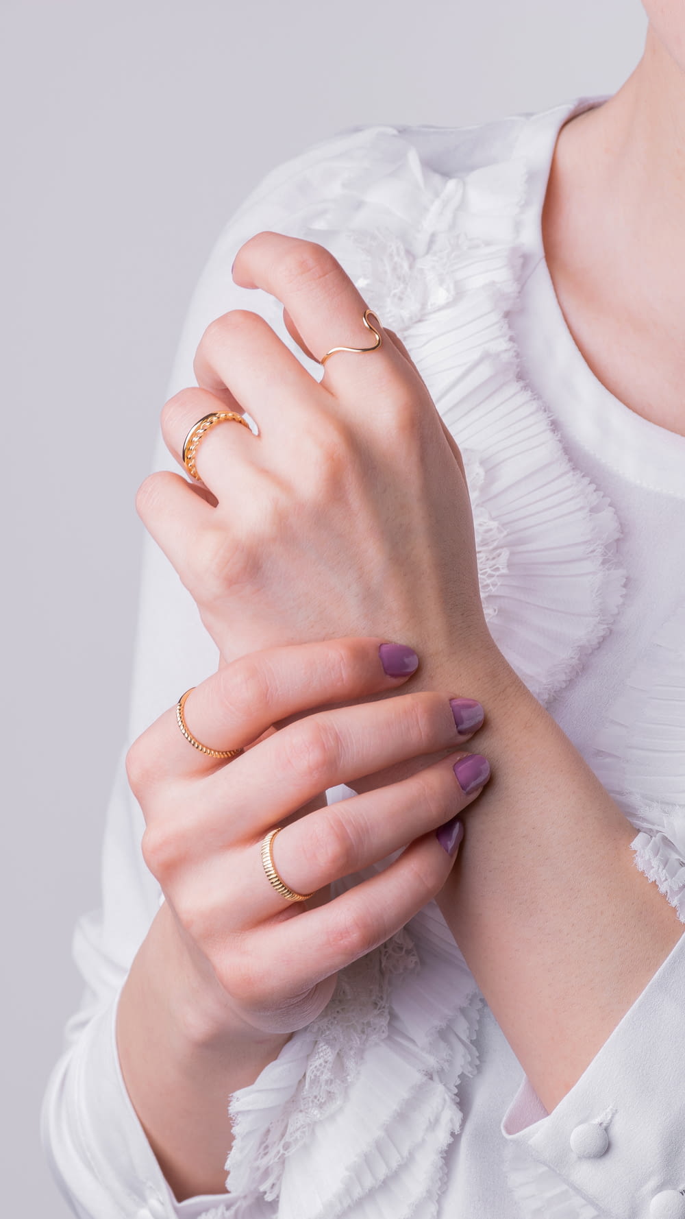 a woman in a white shirt is holding her hands together