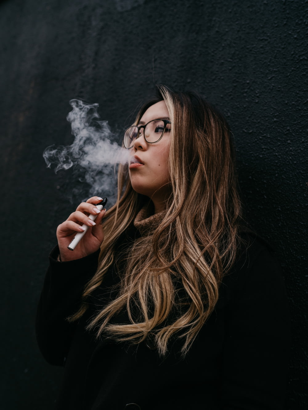 woman in black long sleeve shirt smoking cigarette