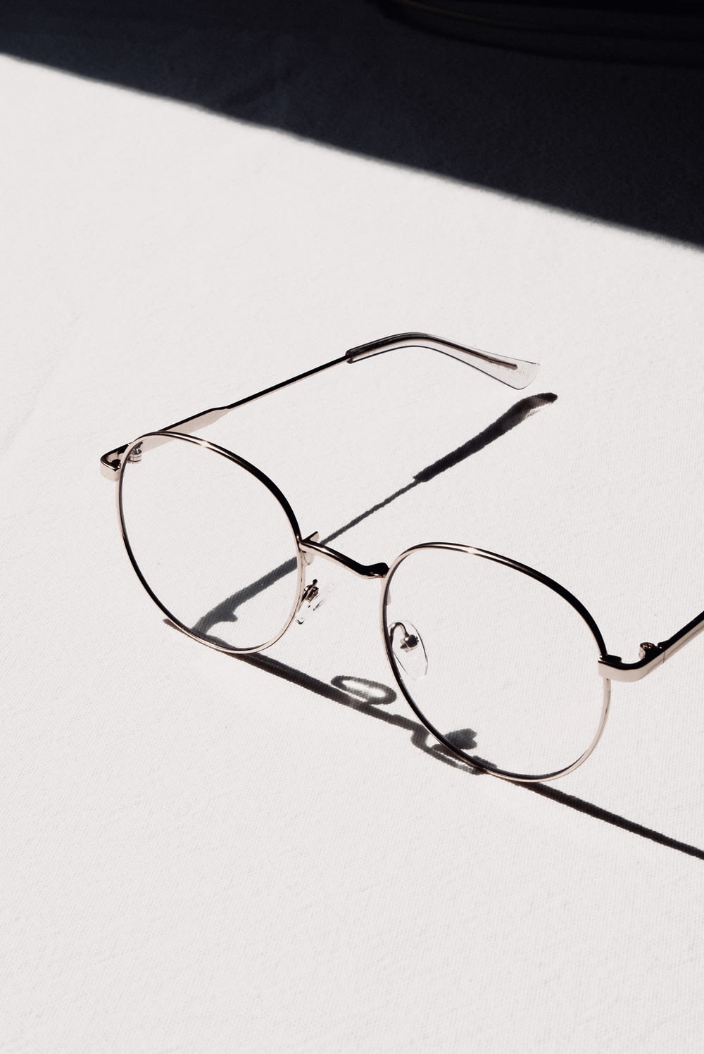 silver framed eyeglasses on white table
