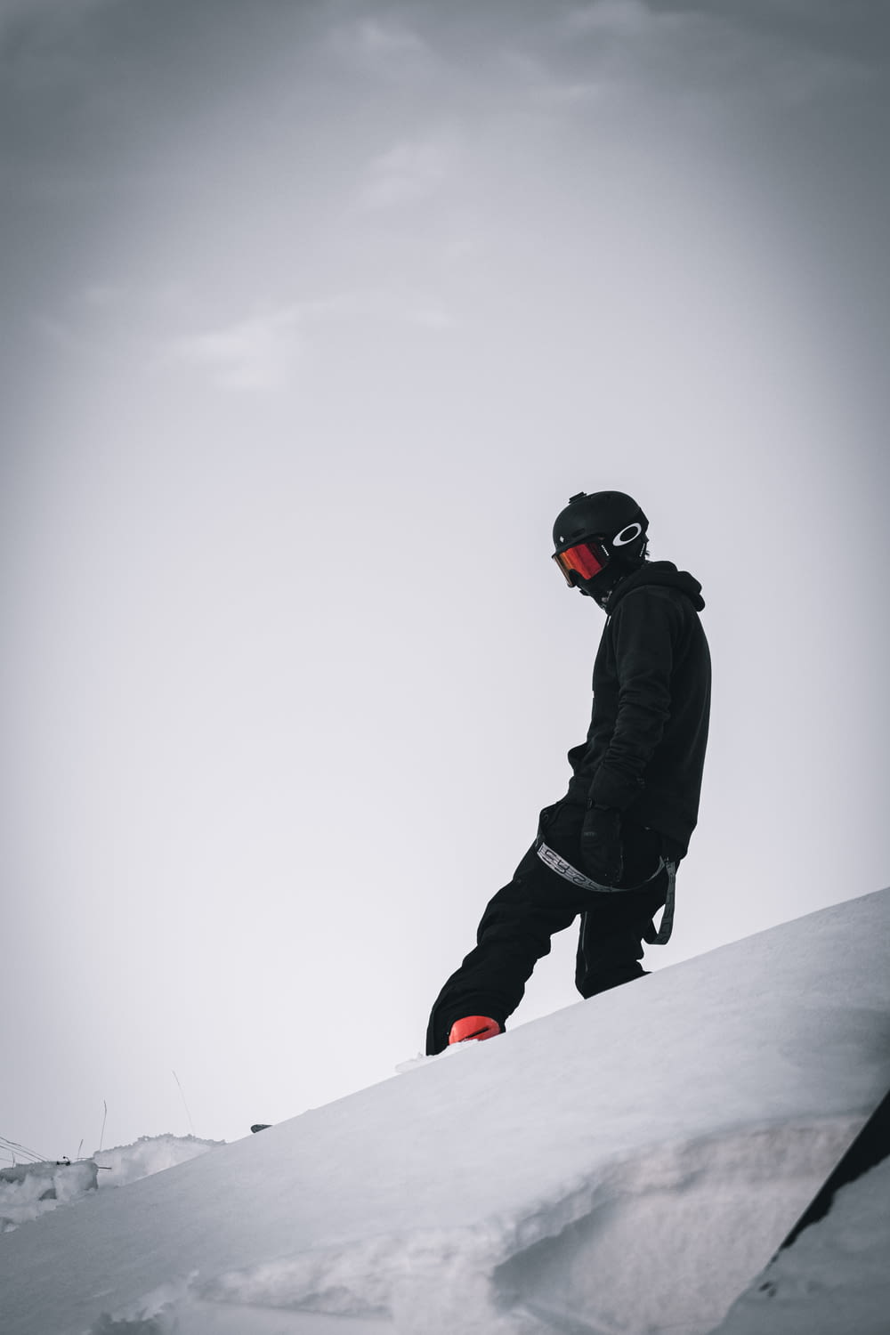 man in black jacket and pants riding on white and red snowboard
